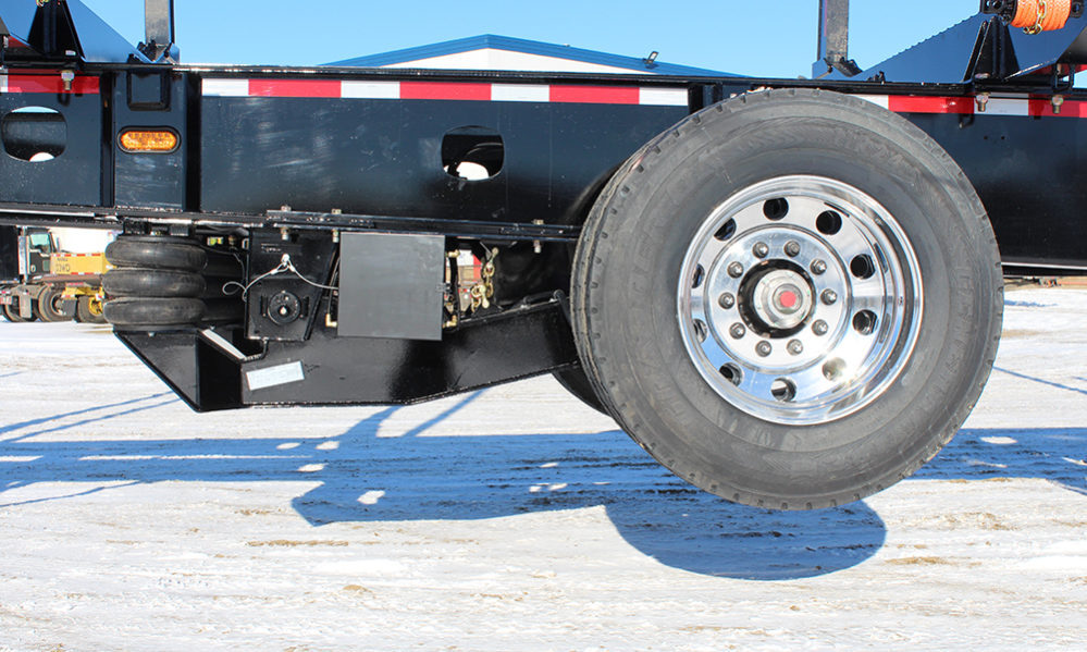Close-up of a lift axle mechanism engaging suspension components
